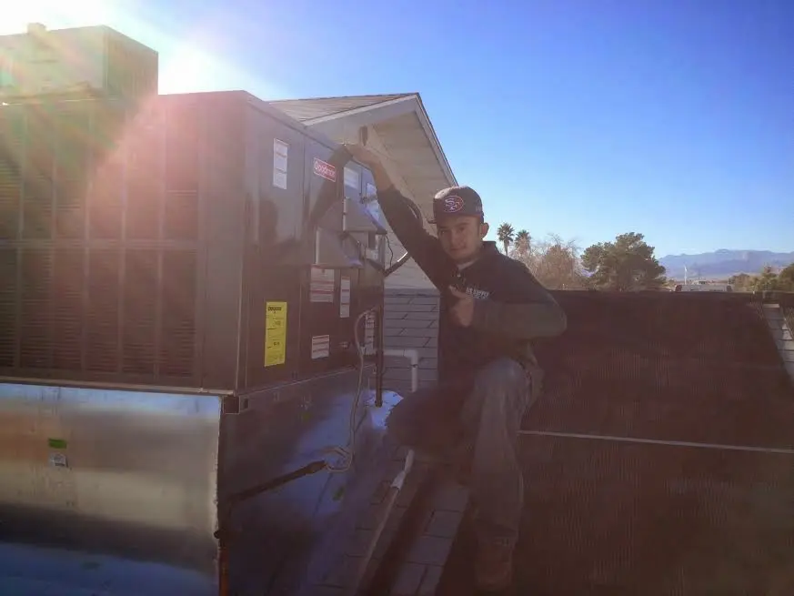 HVAC technician performing AC Tune-Up on a rooftop unit in Lighthouse Point